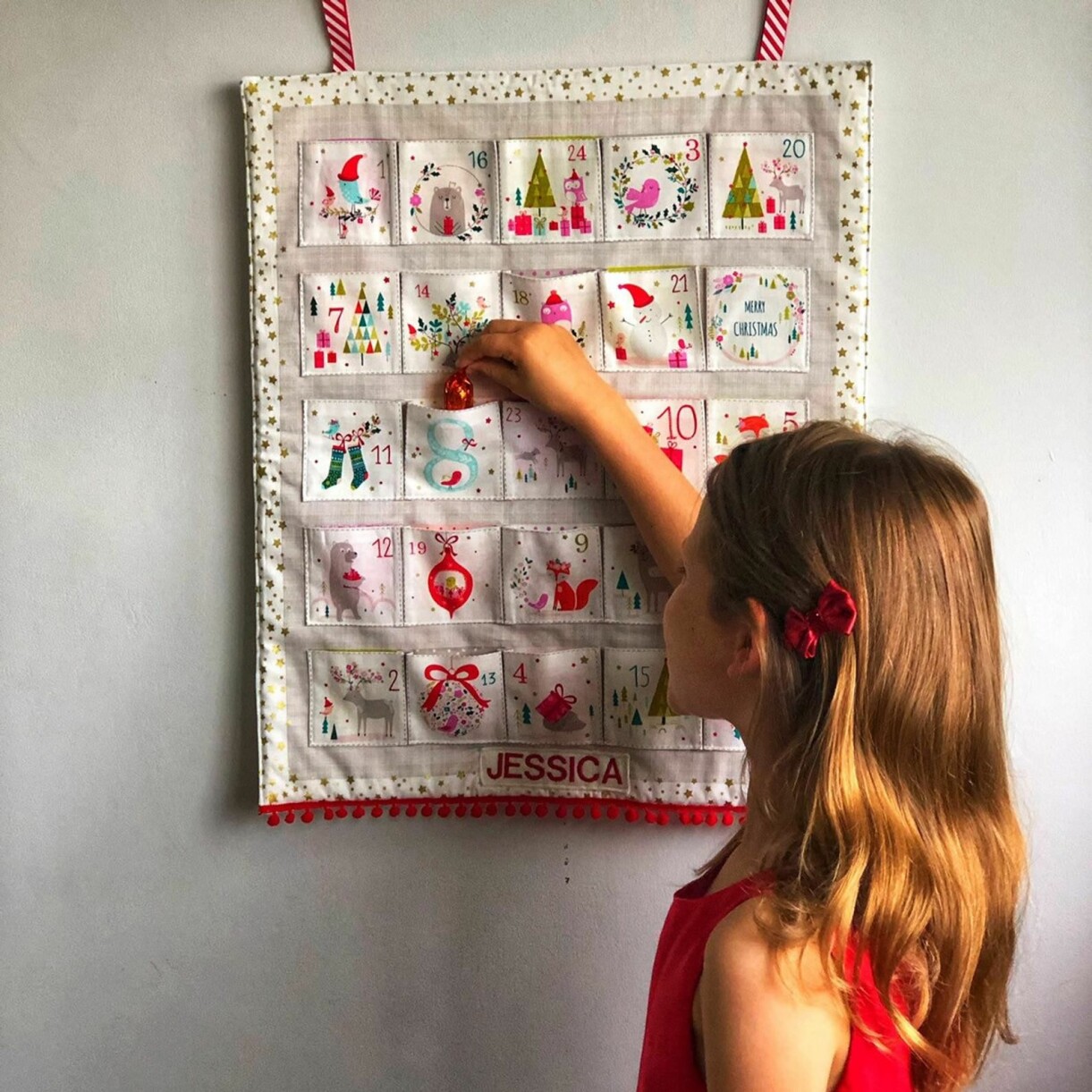 Foto: <a target="_blank" href="https://www.etsy.com/uk/listing/738713585/handmade-personalised-fabric-advent?ref=shop_home_active_4&amp;frs=1&source=aw&awc=6091_1604660471_706c21cbd8d287bc4f5aed5437b9badc&utm_source=affiliate_window&utm_medium=affiliate&utm_campaign=uk_location_buyer&utm_content=239763&utm_term=146559%7C207359">LilyAndGiraffe</a> Adventskalender i tyg på väggen