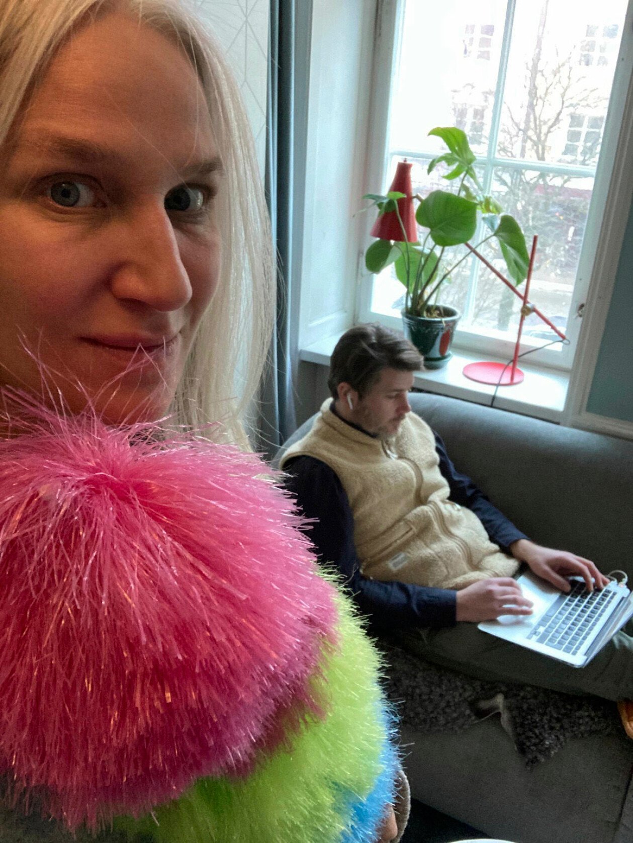 Ann med dammvippan i högsta hugg och Mathias framför datorn med öronsnäckorna i. Ann med dammvippan och Mathias med öronsnäckorna framför datorn