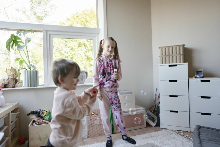 Conor och Valeriia har funnit varandra och lär sig varandras språk. En liten pojke och en lite äldre flicka leker i ett barnrum i en ljus villa.