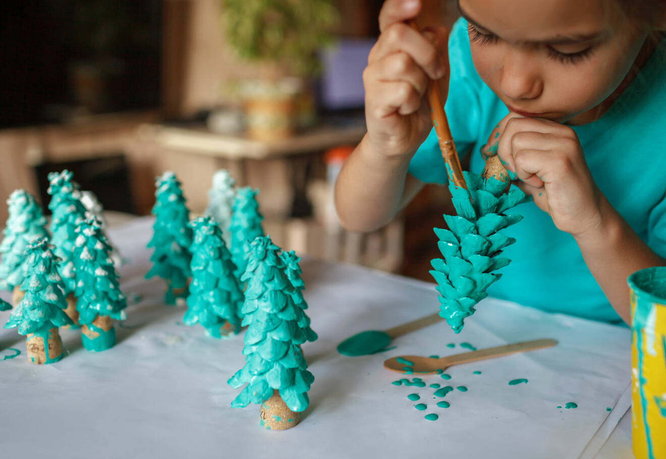 barn som målar granar som julpyssel