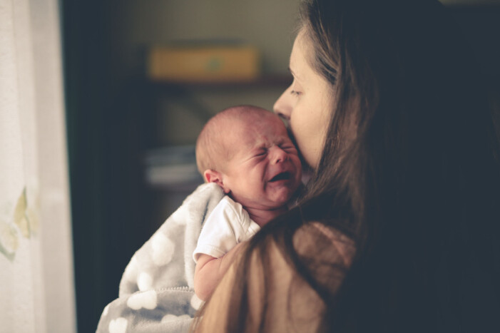 Att vara nära sitt barn kan hjälpa när föräldraskapet känns svårt. mamma håller om skrikande bebos