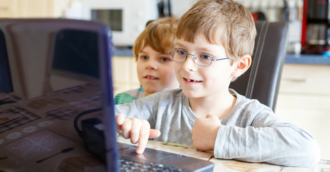 Två barn sitter framför en dator tillsammans