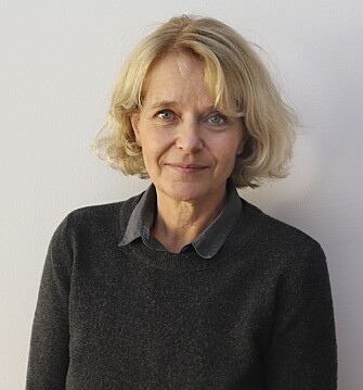 Clara Hellner, professor i barn- och ungdomspsykiatri vid Karolinska Institutet. Clara Hellner står framför en vit vägg och tittar in i kameran.