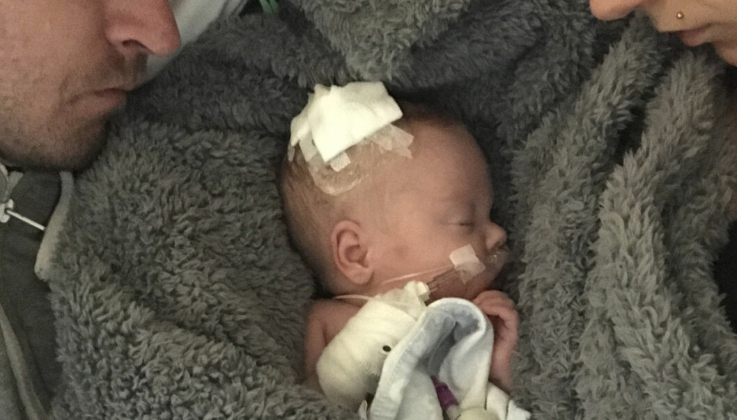 Elton ligger nyfödd på sjukhuset på en filt mellan mamma och pappa.
