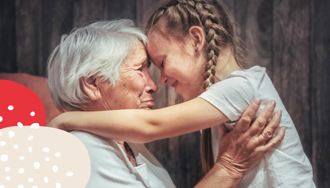 gammal kvinna med vitt hår kramar sitt barnbarn som har flätor i håret