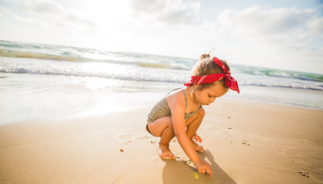 Flicka leker på stranden