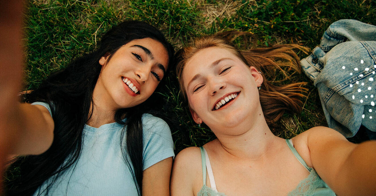 Två unga tjejer som tar en selfie och ler
