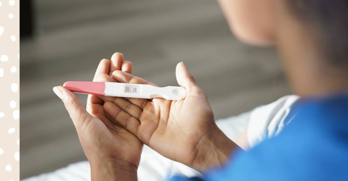 kvinna som håller i graviditetstest