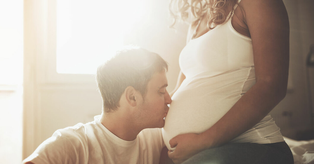 Man kysser gravid kvinnas mage.