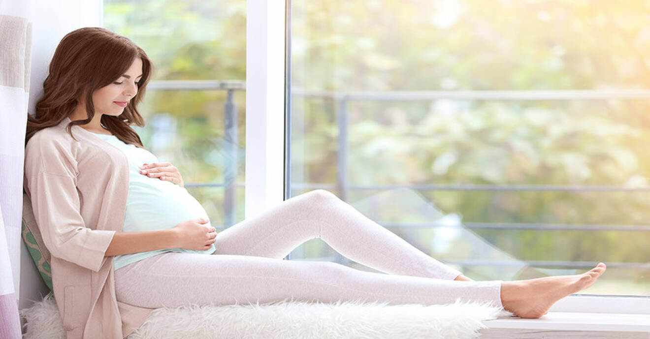 Gravid kvinna i fönster