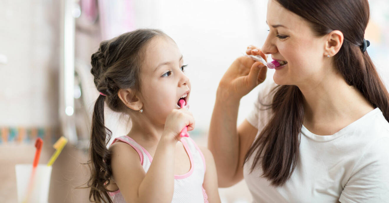 Mamma och barn borstar tänderna