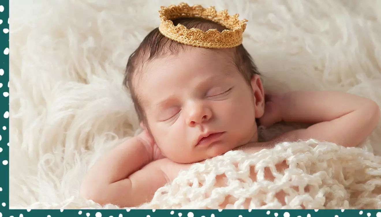 Liten bebis med virkad krona på huvudet.