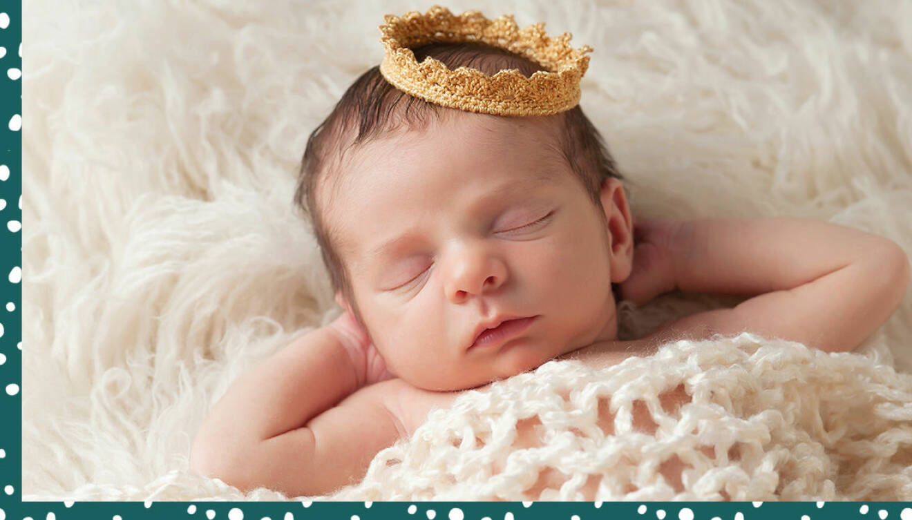 Liten bebis med virkad krona på huvudet.