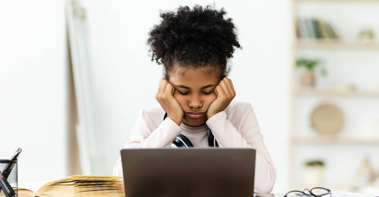 Tonårstjej som är trött framför datorn