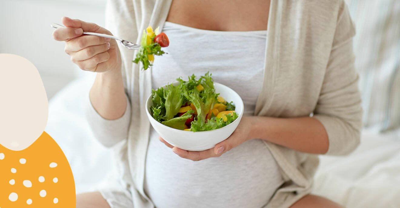 Gravid kvinna äter sallad