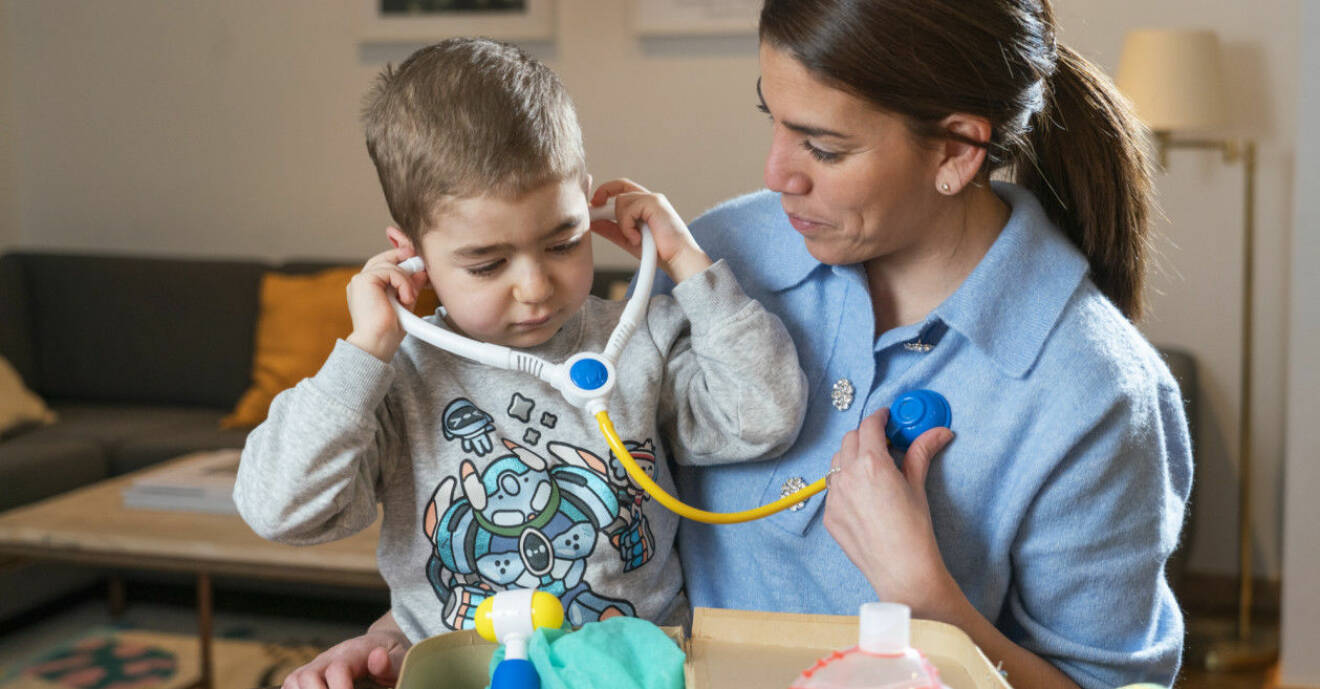 Paola Palacios med sin hjärtsjuke son Nicolas som leker med ett leksaksstetoskop.