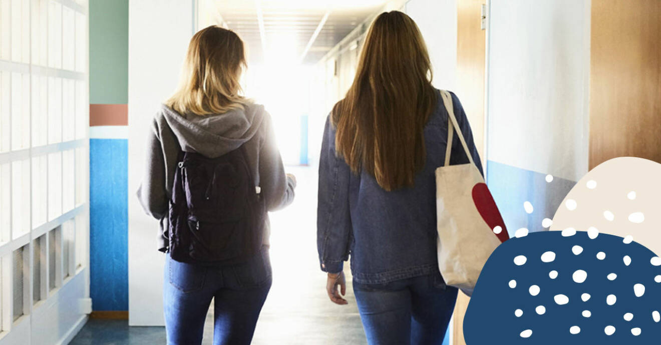 Ryggen på två tjejer som går i en skolkorridor