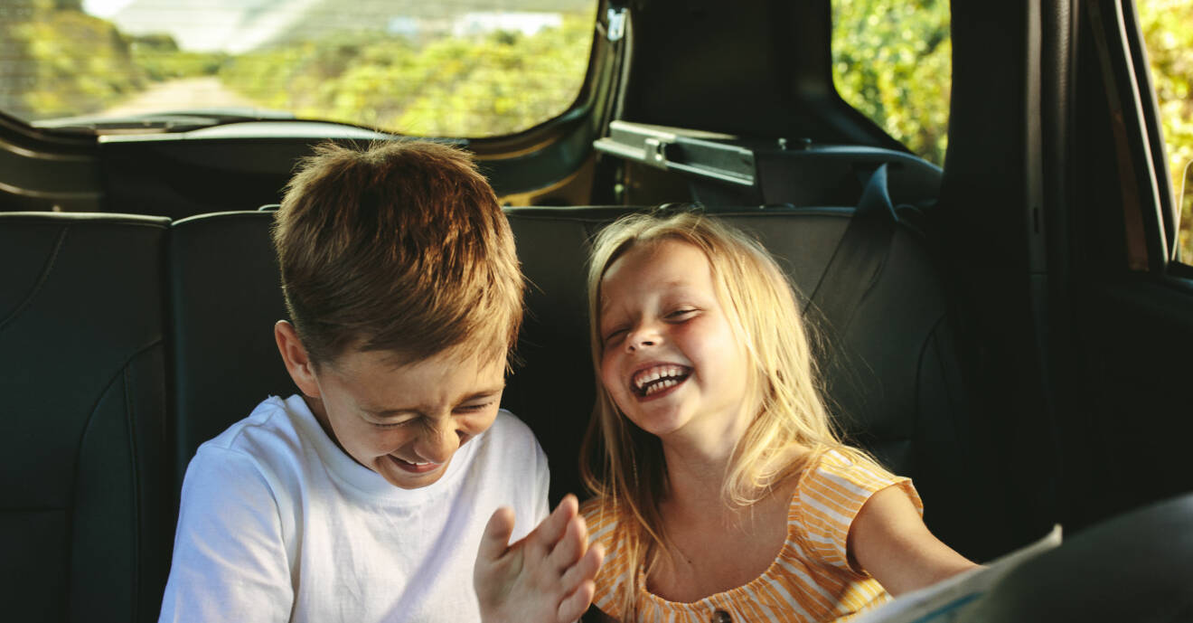Två barn skrattar i bilen
