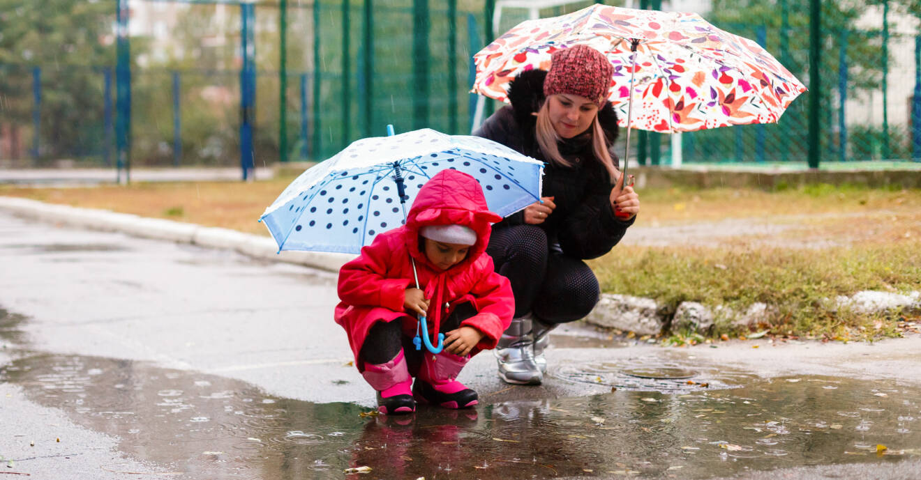 mamma och barn går i regn