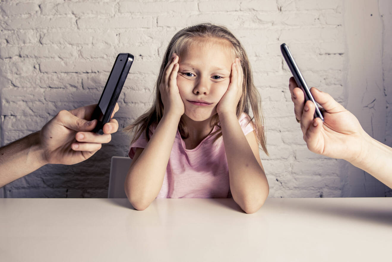 barn och föräldrar som håller i mobiltelefoner