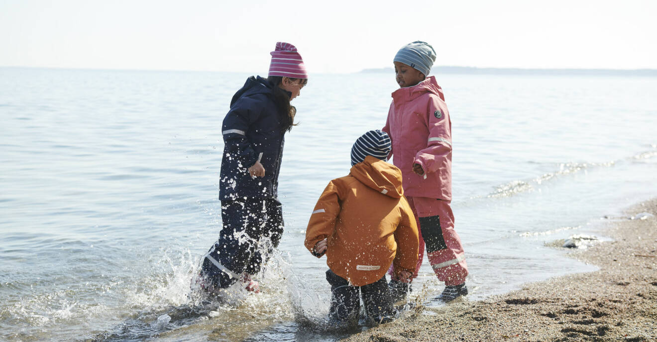 barn plaskar vid strandkanten