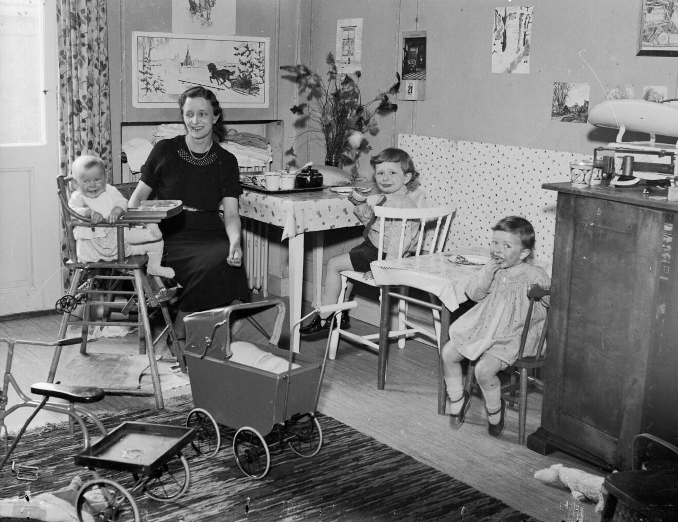 mamma med barn i rum med leksaker på 1930-talet