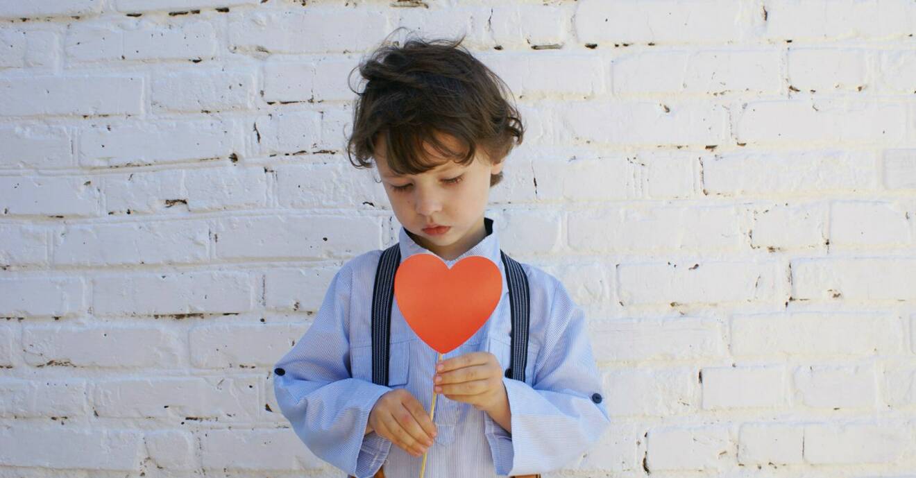 Pojke som håller i ett pappershjärta.