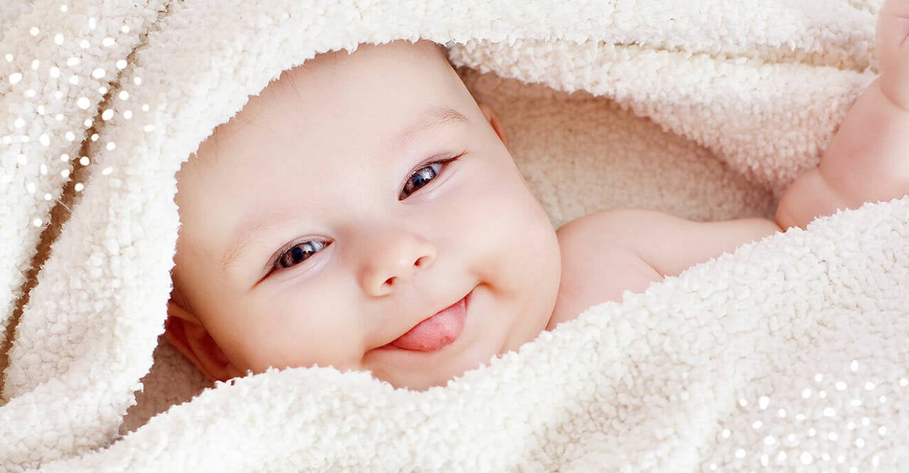 glad bebis i handduk efter badet