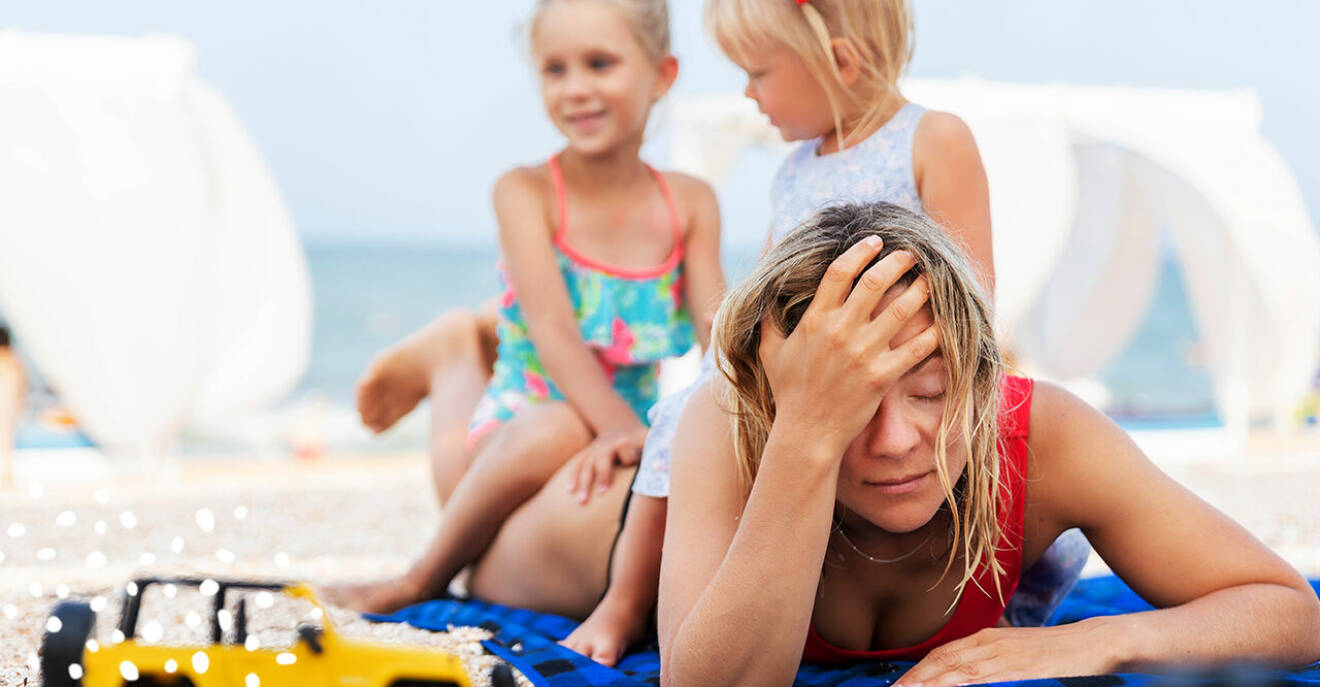 mamma trött på stranden med barnen