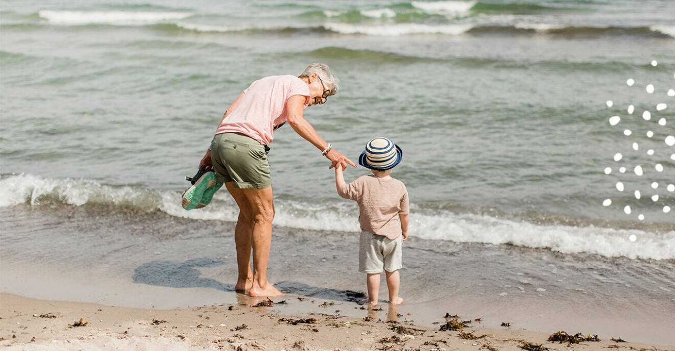 mormor och barnbarn på stranden