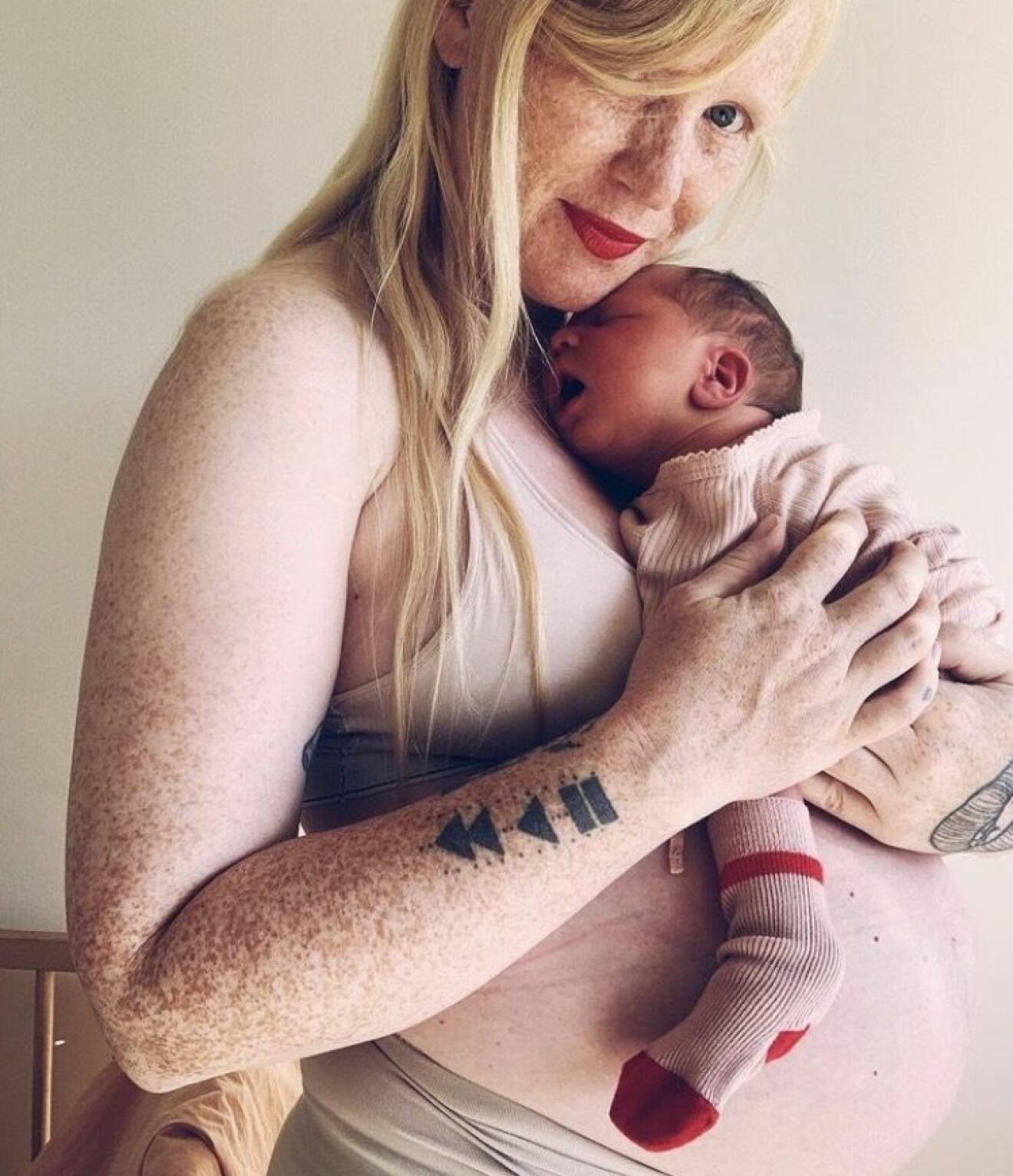 Jessica Hallbäck håller bebis i famnen