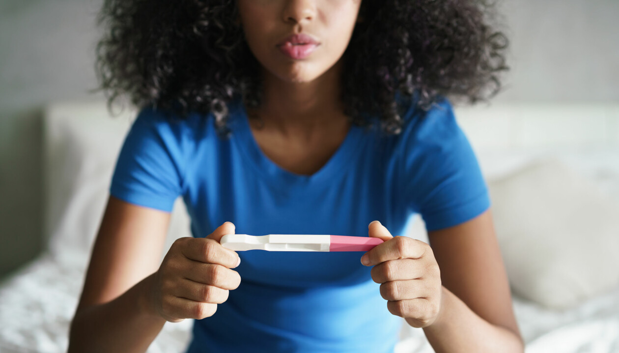 Kvinna som tittar på graviditetstest