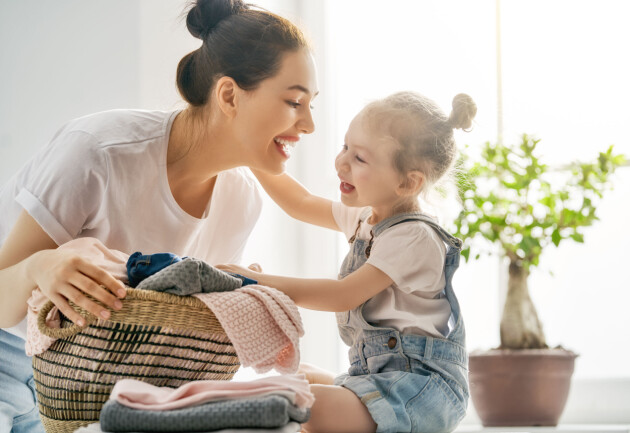 Tips från redaktionen! Ha en korg i hallen som storasyskonet kan lägga sina smutsiga förskolekläder i och klä istället barnet i rena hemmakläder för att vara på den säkra sidan. Mamma och dotter med en korg med kläder i