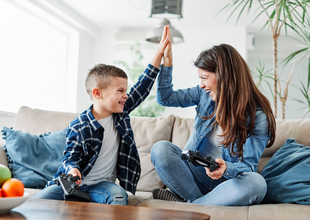 Få koll på vad kidsen gör på skärmen genom att låta dem utmana dig på spel. mamma och son som spelar tv-spel
