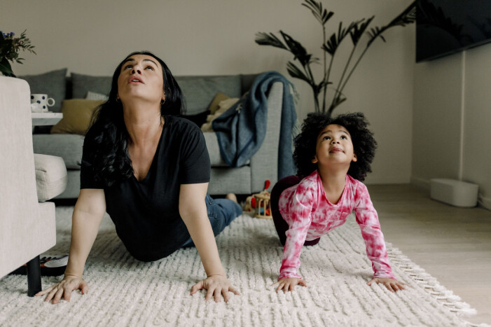 mamma gör yogaövning med sin dotter