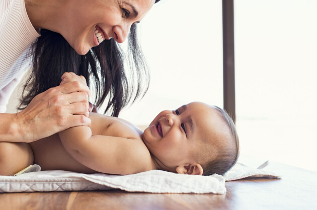 Tips! När du byter blöja, försök få till en så avslappnad och härlig stund som möjligt. Då är det lättare att lära känna bebisens signaler. mamma och bebis skrattar