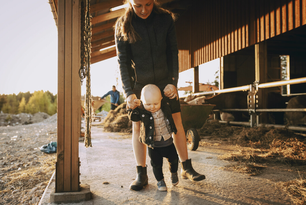 Mamma med barn vid ladugård