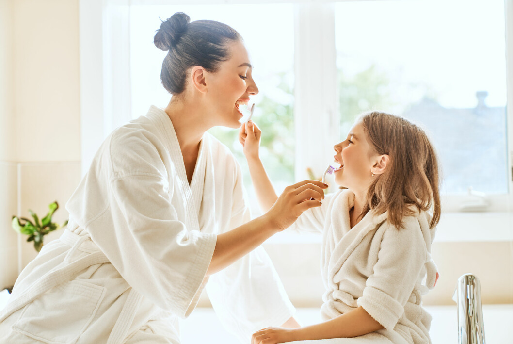 mamma och dotter borstar tänderna