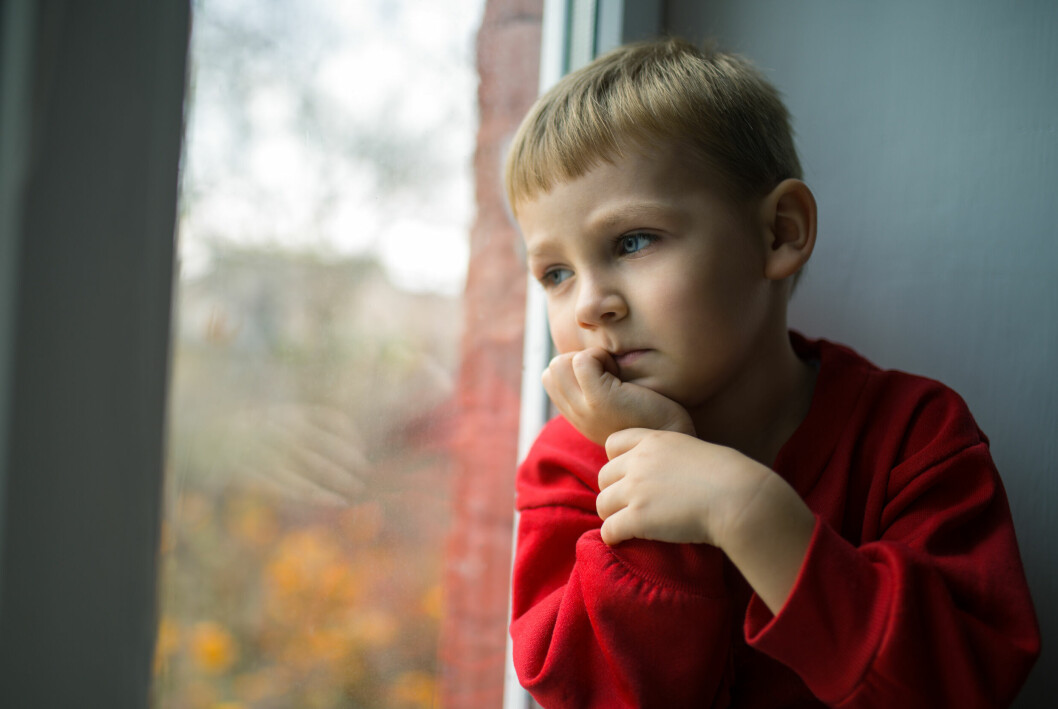Barnet kan bli inbundet, ha svårt att komma till ro eller svårt att koncentrera sig när hen tvingas bära på den här typen av känslor. liten pojke som tittar ut genom ett fönster och är ledsen