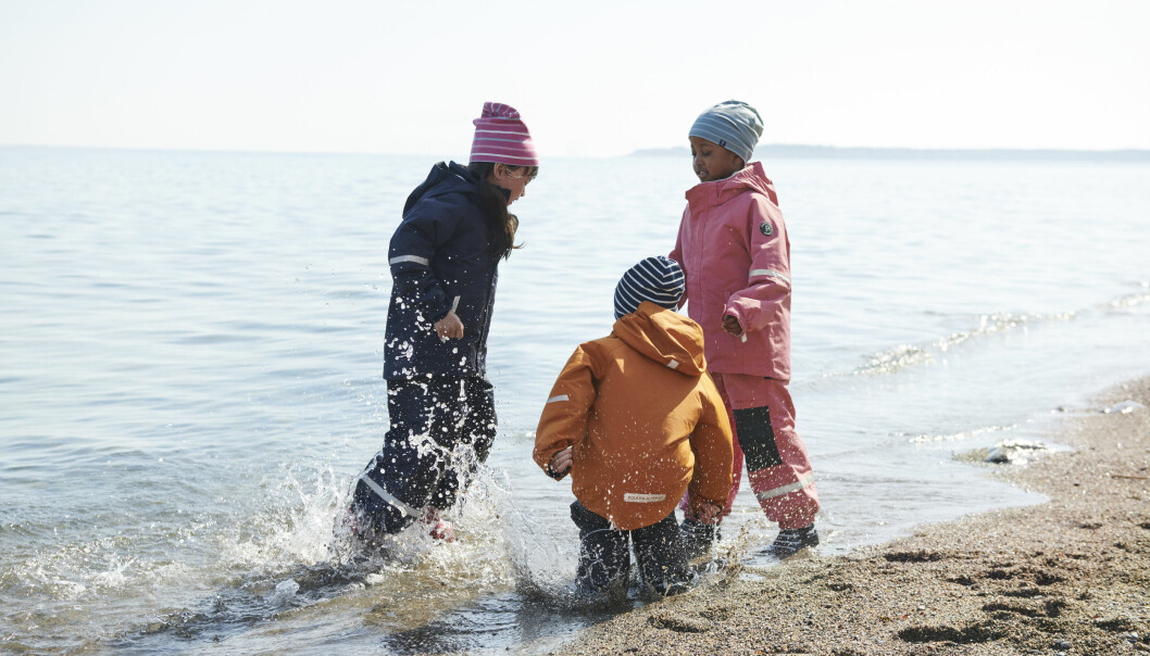 barn plaskar vid strandkanten