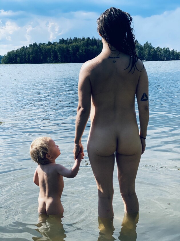 Sandra Aggemo och hennes barn hand i hand blickandes ut mot en sjö
