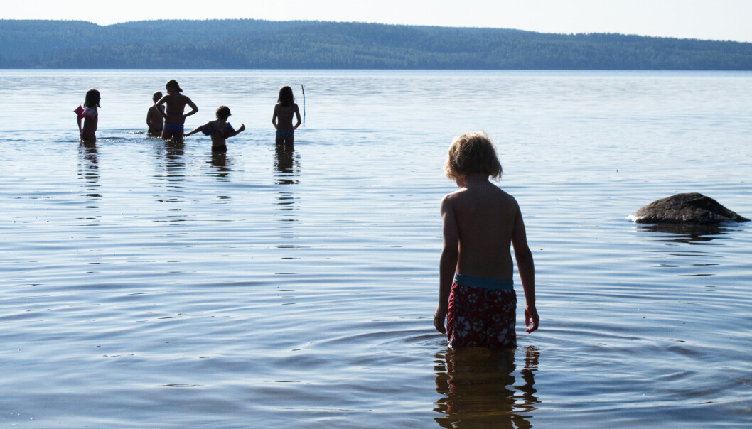 Barn som badar i en sjö.