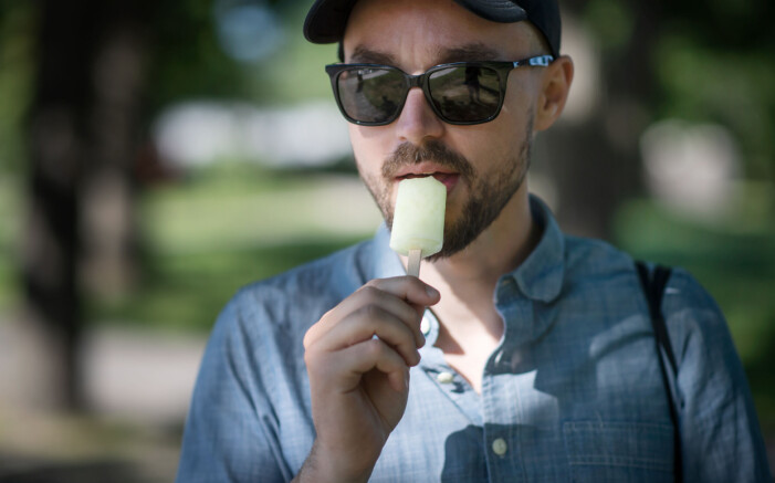 Man som äter glass i solen.