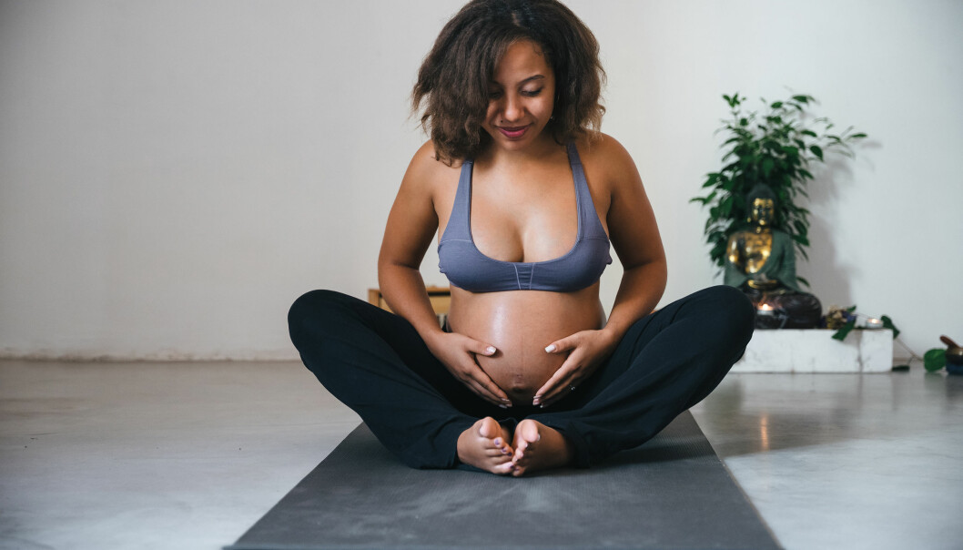 Gravid kvinna yogar inomhus