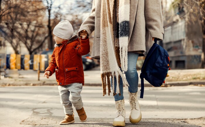 Mysigt med promenad när mamma följer mini till förskolan. pojke går med mamma till förskolan